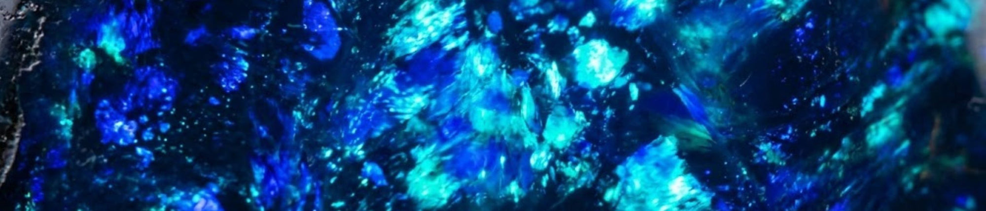 Schwarzer Opal mit leuchtendem Farbenspiel auf dunklem Grund